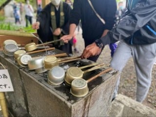 指導を受けながら手水鉢で手と口を清める留学生たち